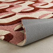 Sienna Swirl abstract hand-tufted rug in cream, peach, and white with warm swirling patterns